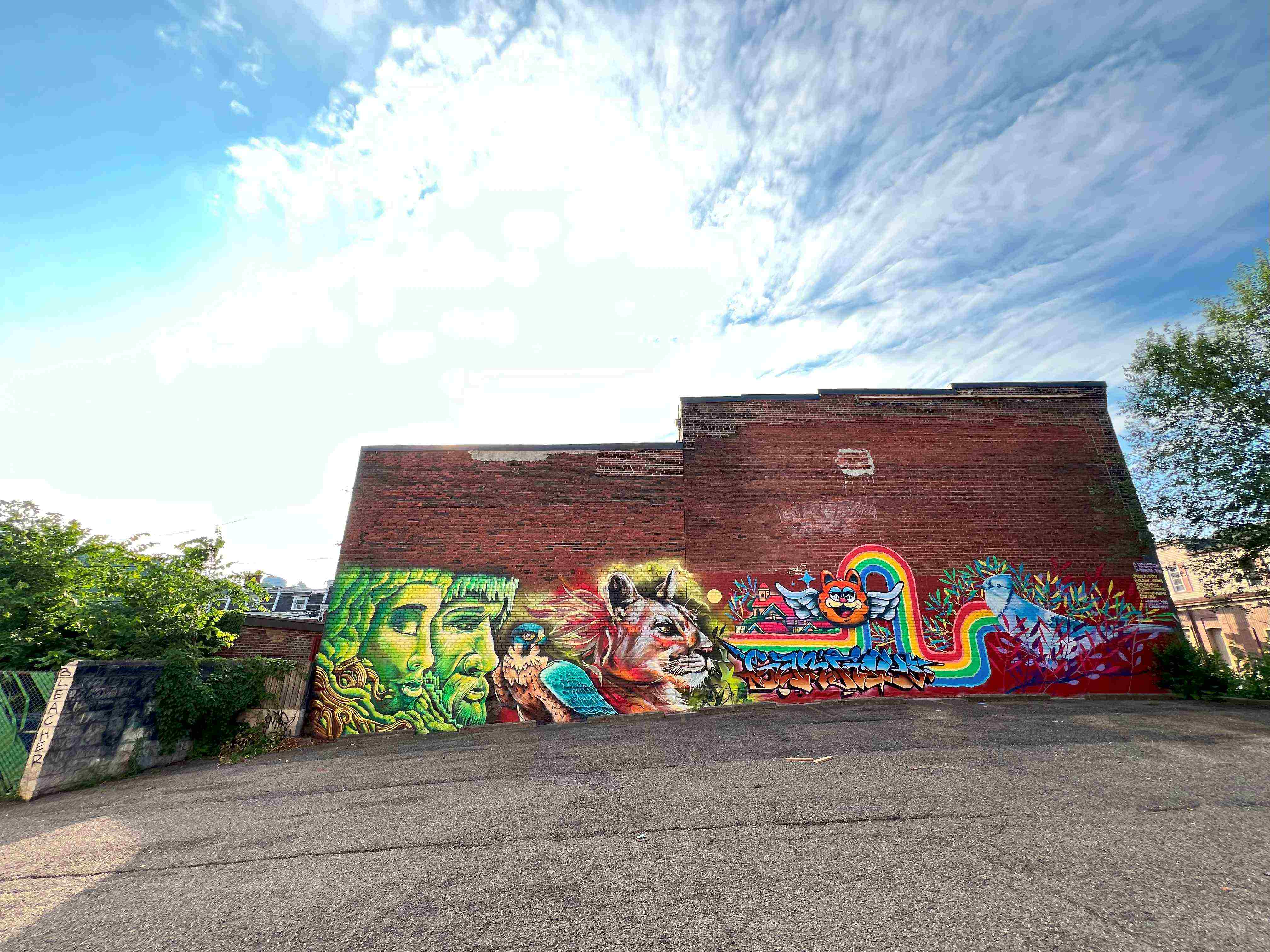 brick building with graffiti in front of blue sky with clouds